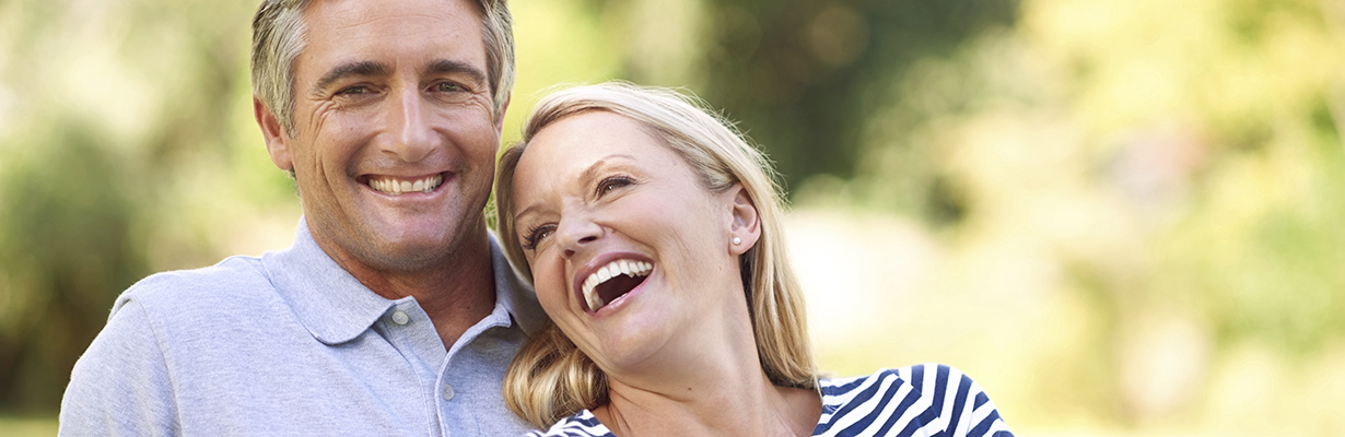 A portrait of a happy mature couple laughing and smilling together outdoors