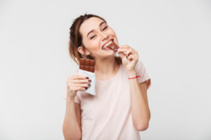 pretty girl biting chocolate bar