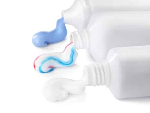 Tubes with toothpaste on white background