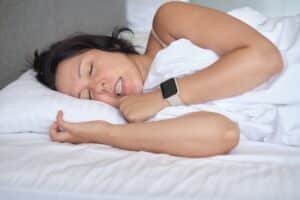 Woman grinding her teeth while sleeping in bed.