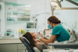 Dentist examining a woman for TMJ concerns.