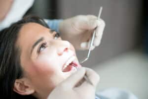 A woman has a broken tooth examined by a dentist.